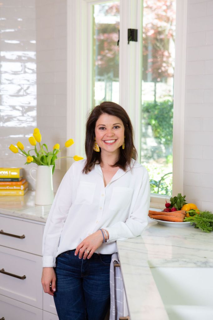 Sophie Dolan MS, RDN, standing in a bright kitchen with fresh vegetables on the counter.