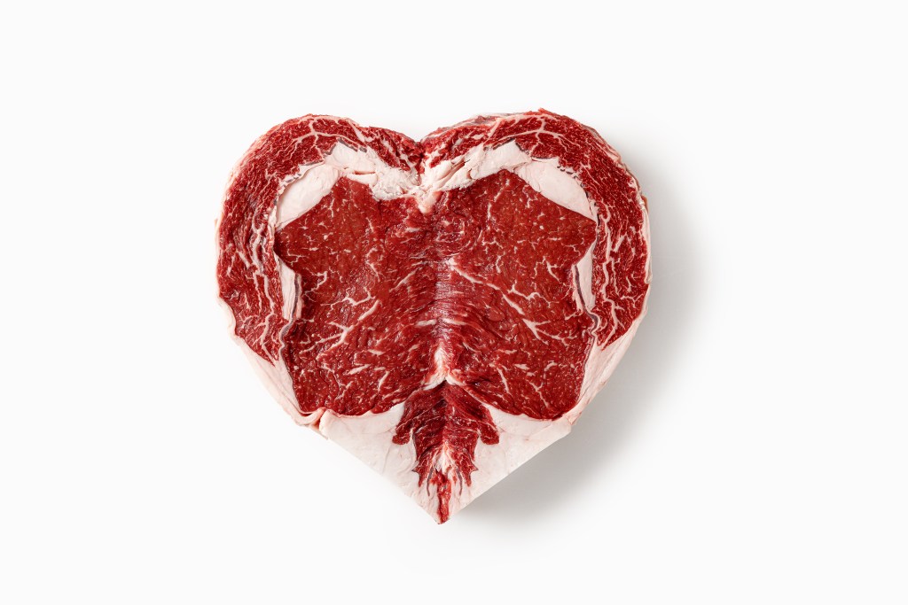 Heart-shaped Certified Angus Beef® ribeye steak showcasing rich marbling on a white background.