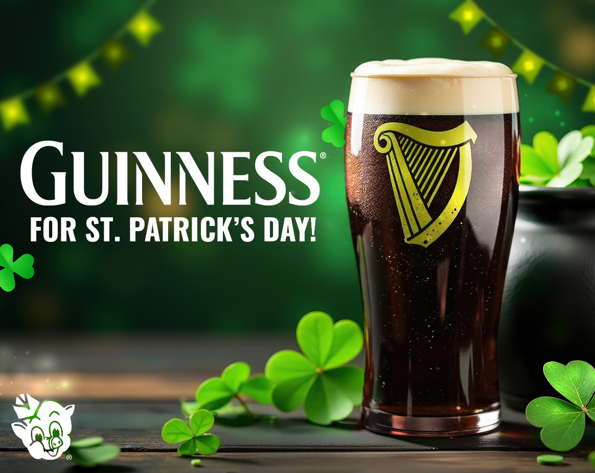 A pint of Guinness stout with a creamy head, surrounded by shamrocks and festive green decorations for St. Patrick’s Day.