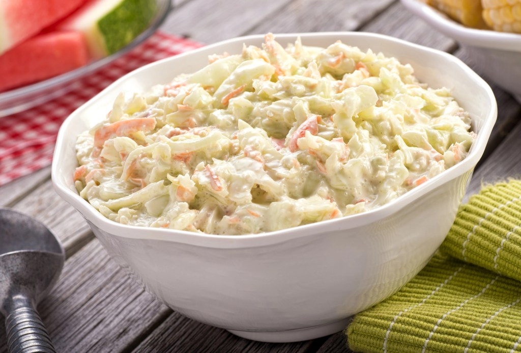 Homemade creamy coleslaw. The coleslaw features finely shredded cabbage and carrots mixed in a rich, creamy dressing.