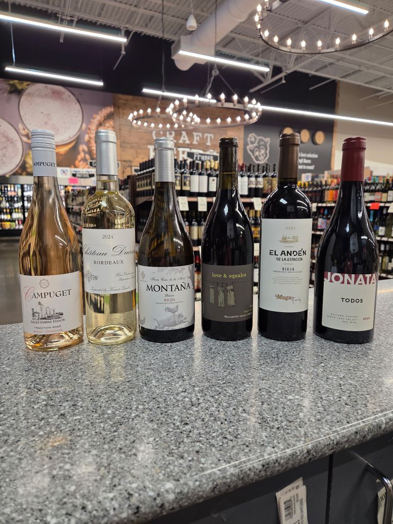 Assorted wine bottles including rosé white and red varieties displayed on a counter at Bluff Park Piggly Wiggly for tasting event