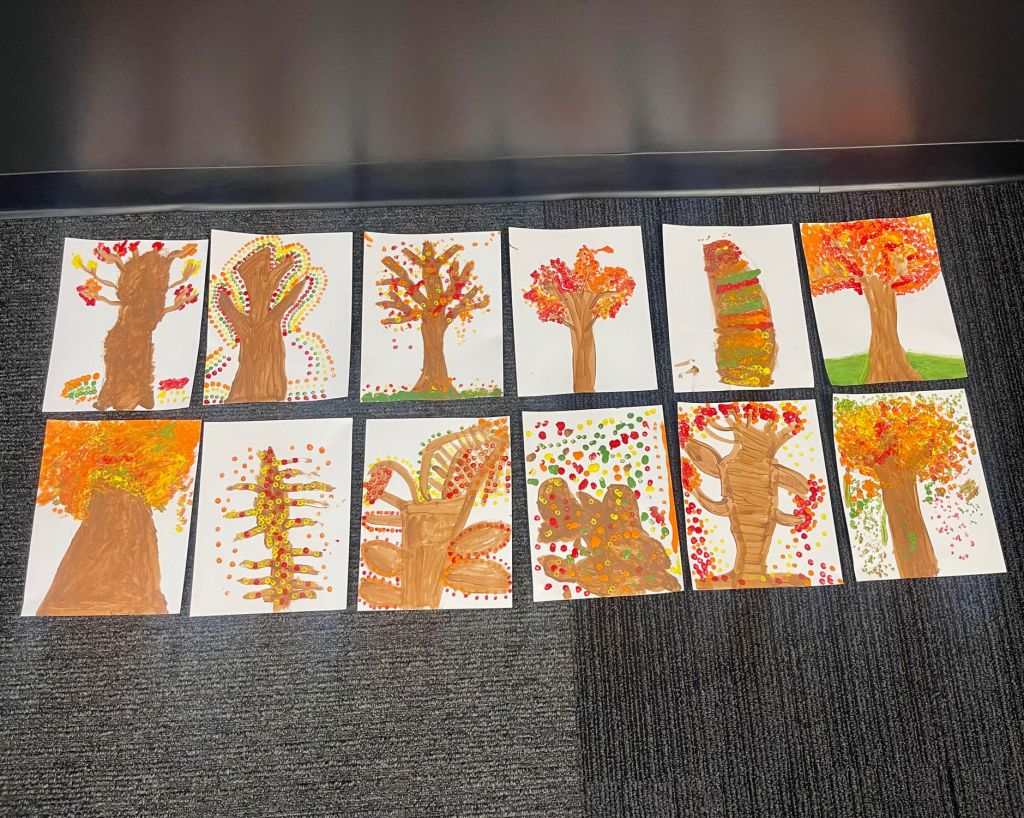 Collection of autumn-themed tree paintings created by adults with disabilities for the 2025 Equip Art Show in Birmingham