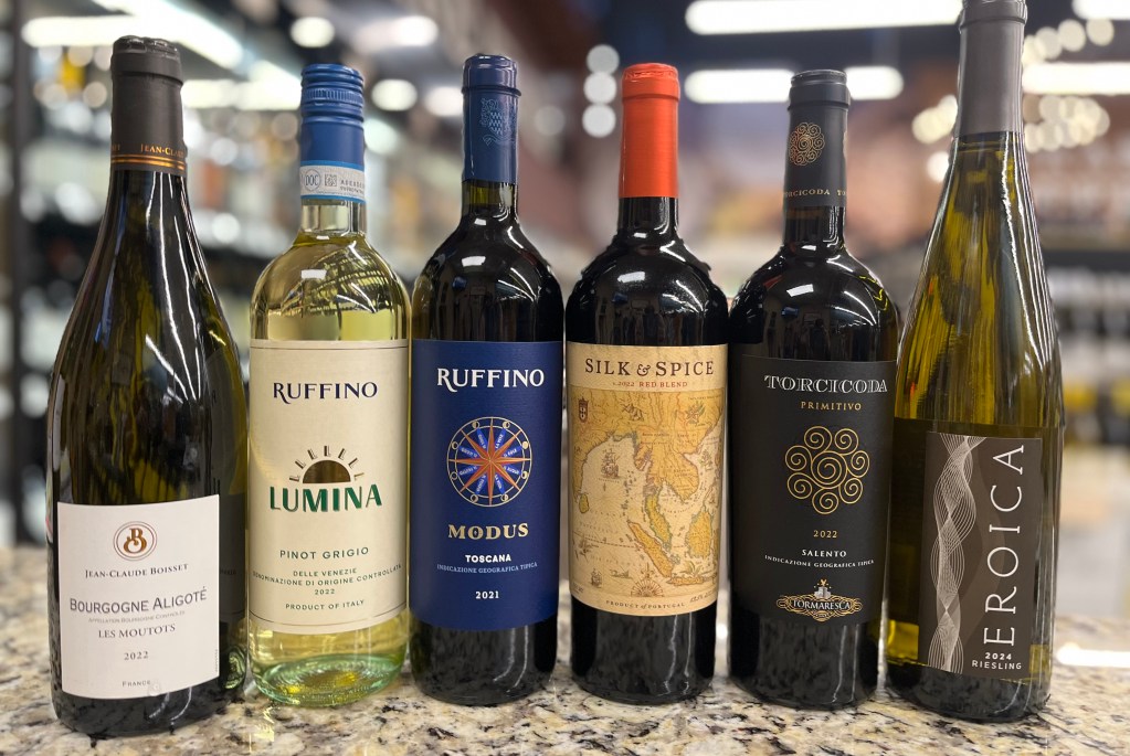 Assorted international wine bottles displayed on a store counter, including Jean-Claude Boisset, Ruffino, Silk & Spice, Torcicoda, and Eroica labels