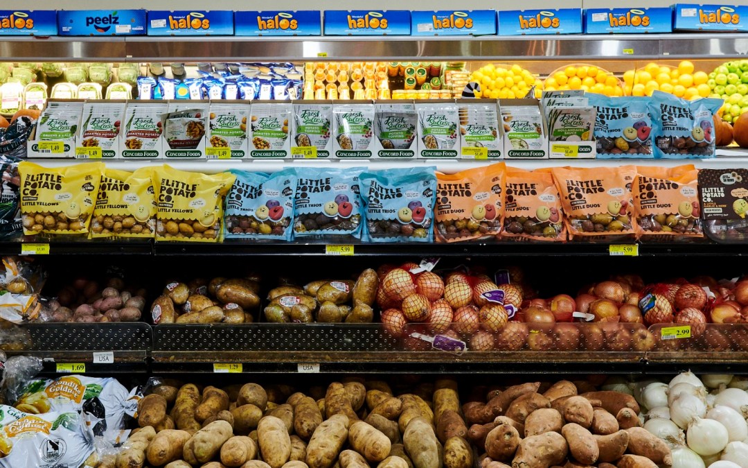 Grocery store produce section featuring fresh potatoes, onions, citrus fruits, and packaged Little Potato Company products at Piggly Wiggly Birmingham