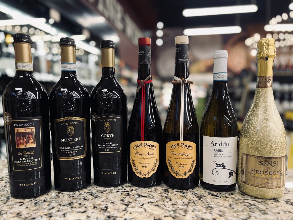 Selection of Italian red and white wines and Prosecco displayed on a counter at Piggly Wiggly for February tasting event