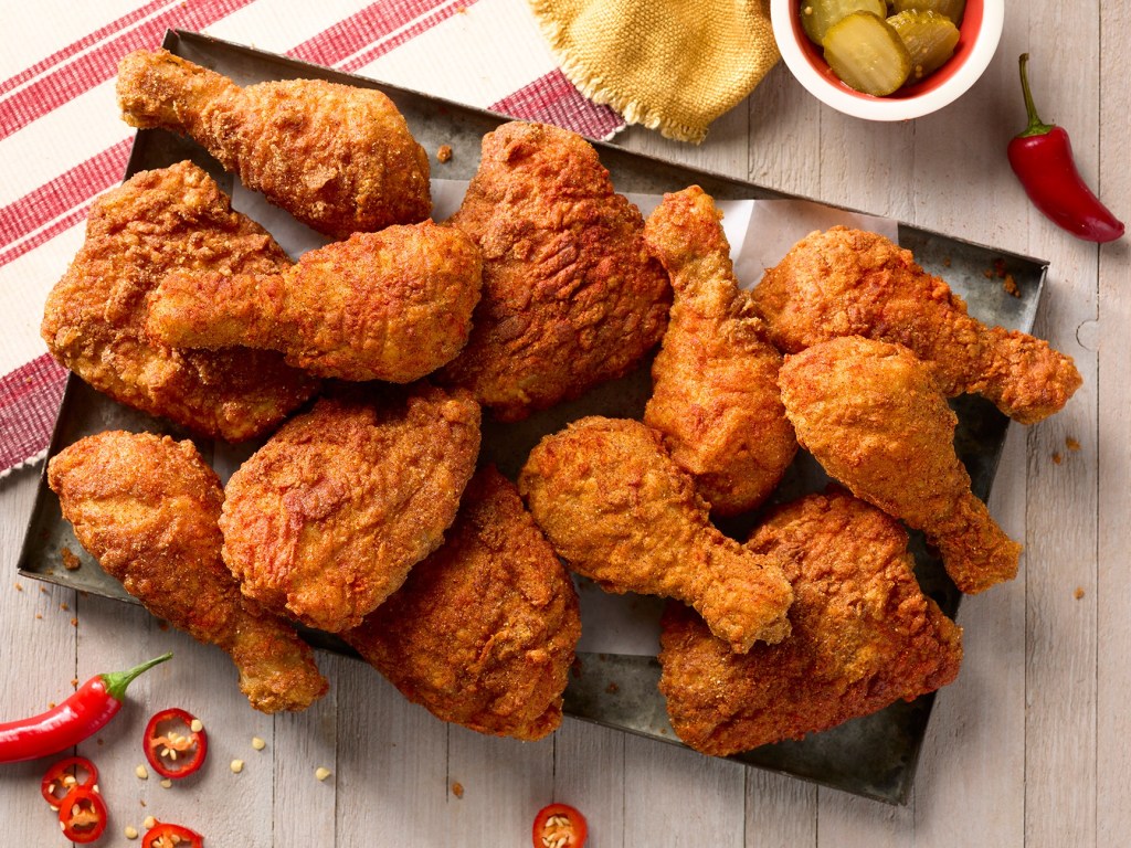 Crispy golden fried chicken drumsticks and thighs seasoned with Louisiana Fish Fry mix on a serving tray