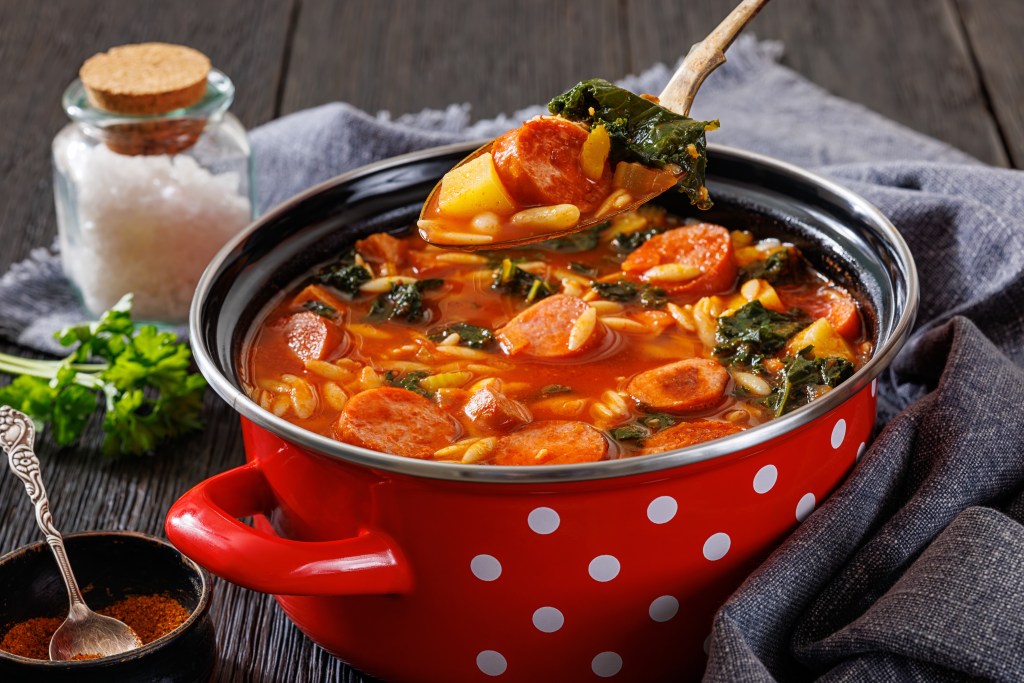 Bowl of hearty vegetable soup with carrots, turnips, kale and cabbage in a rich broth