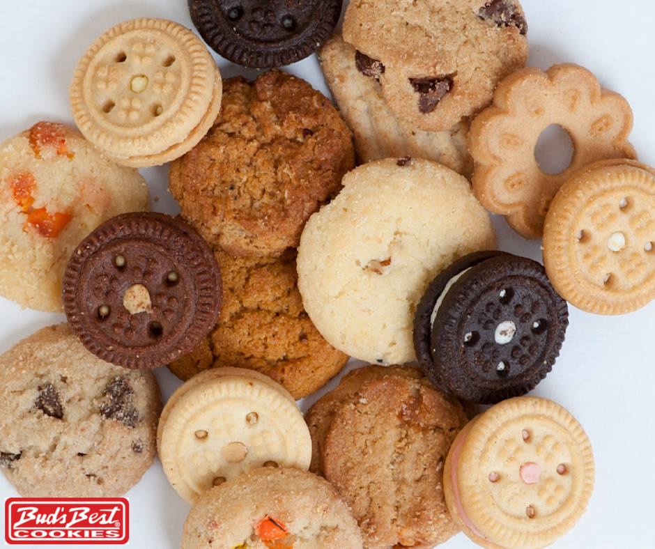 Assortment of Bud’s Best cookies including chocolate sandwich cookies coconut strawberry creme and ginger snaps on a white background