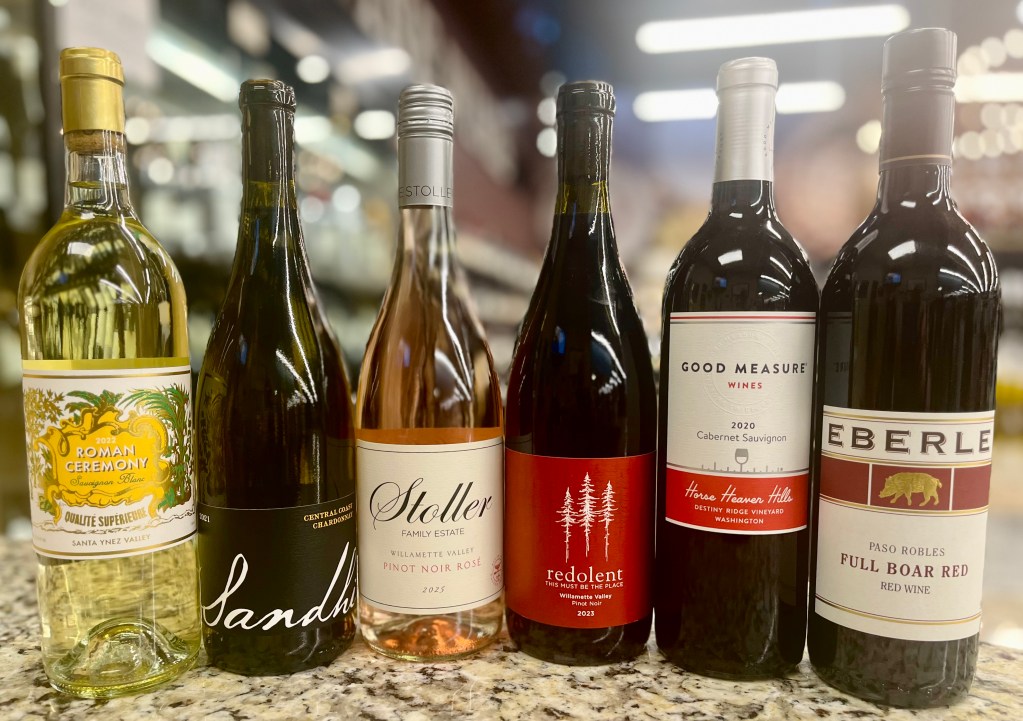 Six featured wine bottles displayed on a countertop for PWB Wine Tastings July 3, including Sauvignon Blanc, Chardonnay, Pinot Noir Rosé, Pinot Noir, Cabernet Sauvignon, and a Paso Robles red blend.