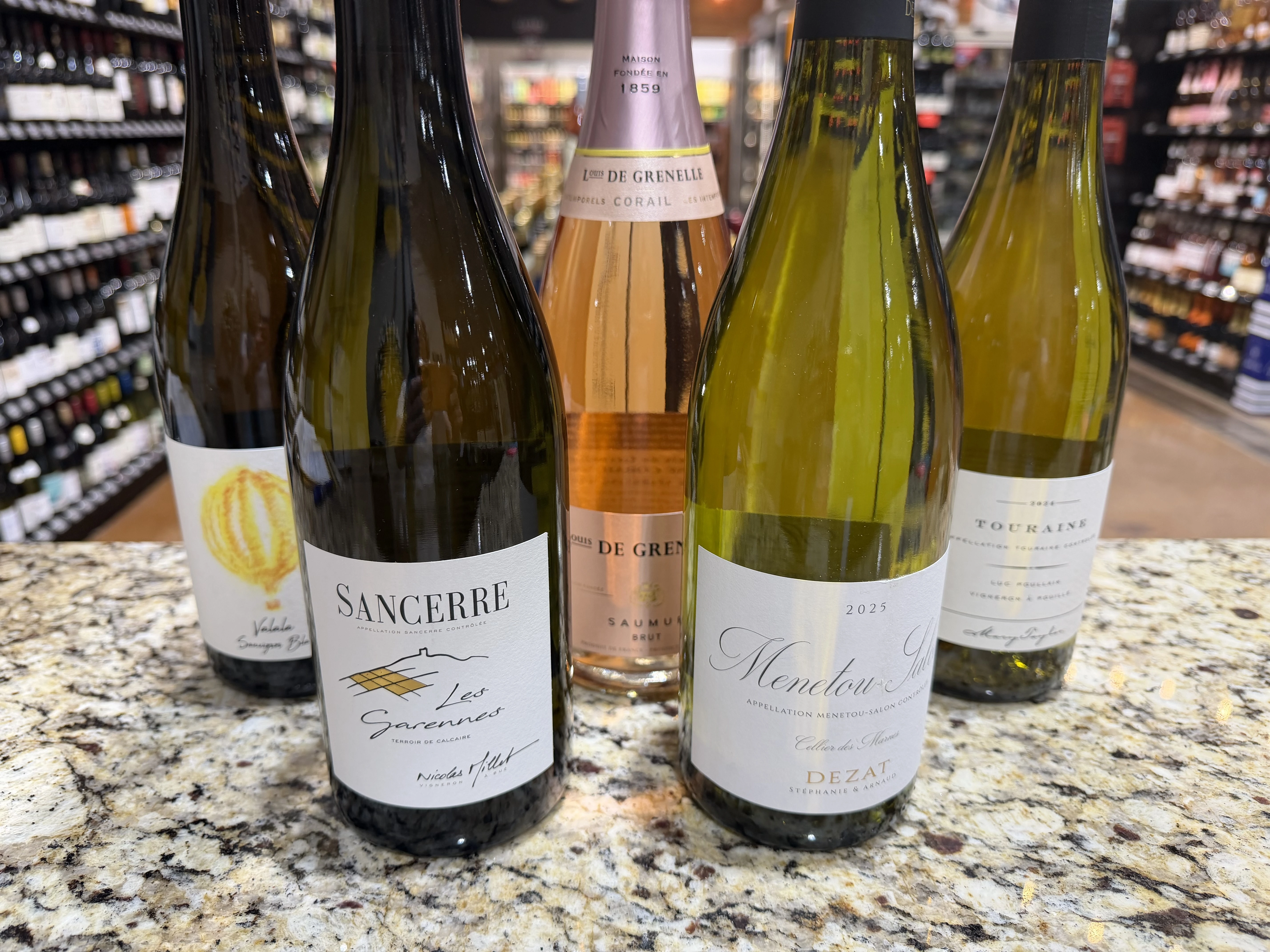 Five wine bottles on a counter in the River Run store photo.